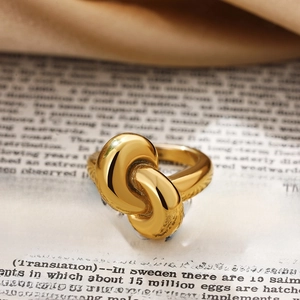 Macro shot of gold knot ring featuring a high-polished finish on vintage book background
