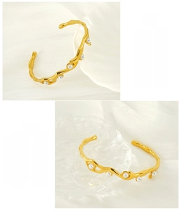 Close-up of gold 18K plated stainless steel open bangle with embedded white pearls