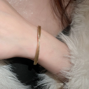 Detailed shot of a gold hollow multi-layer bracelet with pearls on a model wrist