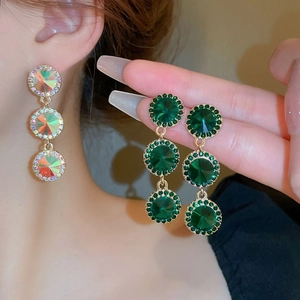 Gros plan de boucles d'oreilles géométriques à trois couches avec cristaux aurore