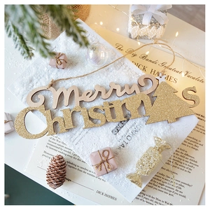 Detail of wooden Merry Christmas sign with gold glitter and pine cone decor