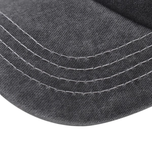 Macro shot of reinforced curved stitching on washed cotton baseball cap brim