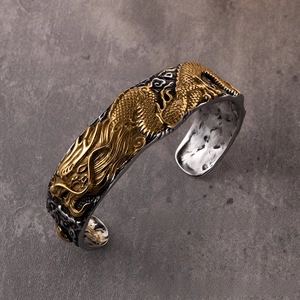 Detail of dragon relief on gold and silver vintage steel bracelet with scales