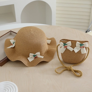 Détail de l'ensemble chapeau et sac en paille avec nœud en maille et cerises