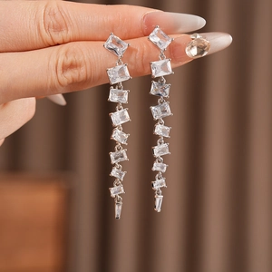 Close-up of sparkling cubic zirconia square tassel earrings with silver needle drop detail