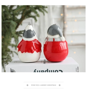 Détail de suspensions Père Noël en céramique sur un livre avec lumières de Noël