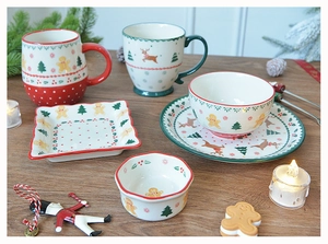 Close-up of Christmas ceramic tableware set with gingerbread man and reindeer patterns