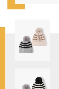 Close-up of thick knitted winter hat showing textured weave and fluffy pom-pom detail