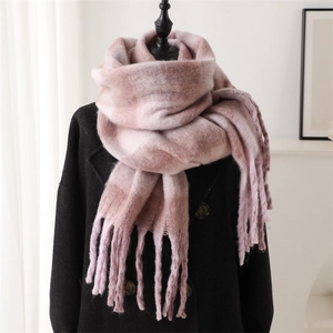 Close-up of pink and brown plaid cashmere-like scarf with fringe on a black coat