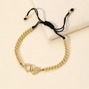 Adjustable woven bracelet with gold heart charm and micro-pave colored zircon stones