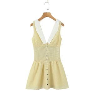 Detail of yellow polka dot V-neck dress with white lace embroidery and black buttons