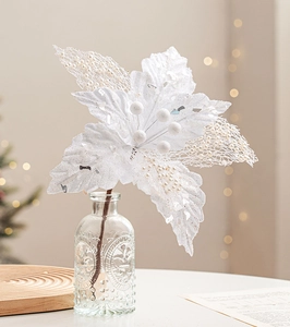 Close-up of artificial white velvet Christmas flower with glitter in a glass vase