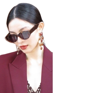 Chic amber resin beaded tassel earrings paired with vintage brown oval frame sunglasses