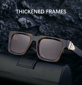 Close-up of tortoise shell sunglasses with thick frames and gold metal hinges on leather case