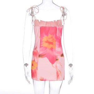 Détails de la mini robe florale avec fines bretelles et nœuds décoratifs sur l'épaule