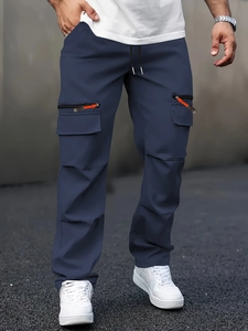 Detail of navy cargo pants with side zipper pockets and orange puller accents
