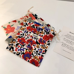 Three floral drawstring cosmetic pouches with Sozakka label in red, purple, and yellow