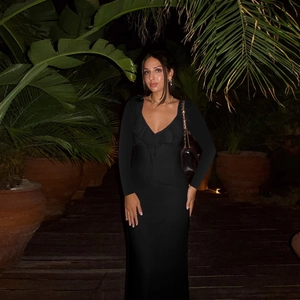 Detail view of the ruffle V-neckline and drawstring on this black bodycon dress