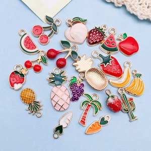 Flat lay of colorful enamel fruit charms including cherry strawberry and watermelon