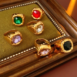 Dettaglio di anelli vintage dorati con zirconi quadrati colorati in una cornice