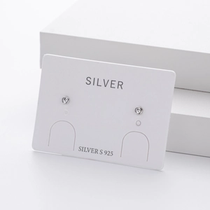 Macro detail of S925 sterling silver stud earrings with round cubic zirconia on white card