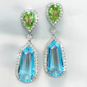 Close-up of aquamarine and olive green teardrop earrings with pave-set zircon details