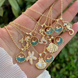 Marine 18K gold plated necklace set with seahorse and starfish pendants in hand