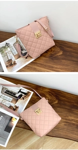 Close-up of pink quilted crossbody bag with golden metal twist lock and leather texture