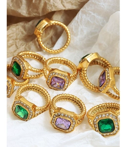 Nahaufnahme von Vintage-Goldringen mit quadratischen Smaragd- und Amethyst-Zirkonsteinen