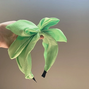 Oversized seersucker bow headband in vibrant green fabric with soft textured finish