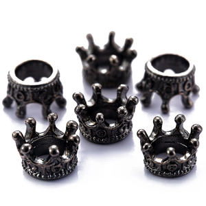 Detailed macro view of six vintage bronze alloy crown pendants on white background