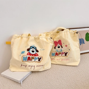 Detail of cute puppy embroidery on beige canvas drawstring tote bags on white rug