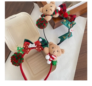 Detailed view of a plush Christmas bear headband with sequin bow and festive tree decor
