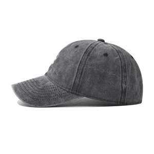 Side view detail of a dark grey washed cotton baseball cap with vintage distressed texture
