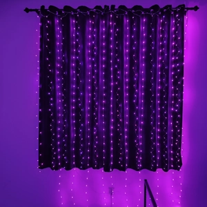 Detail of hanging purple LED curtain lights string on a dark fabric background