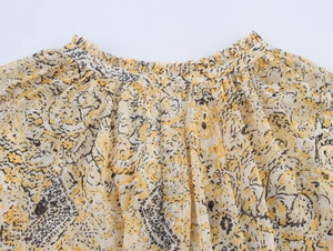 Detail of elastic ruffled waist and vintage black floral print on beige fabric