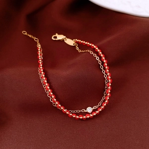 Close-up of dual-layer red cord and 18k gold plated chain bracelet with zircon stone