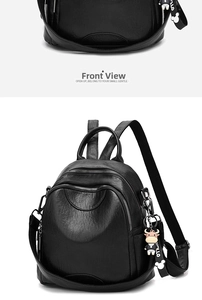 Front detail of black PU leather backpack featuring dual zippers and cartoon charm