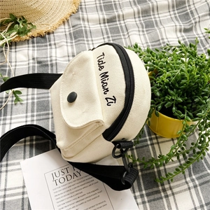 Detailed close-up of cream canvas crossbody bag on aesthetic checkered fabric background