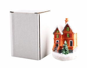 Mini Christmas resin house in orange and white next to its white packaging box