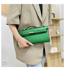 Detail of green leather handbag featuring a gold-tone lock clasp and top handle