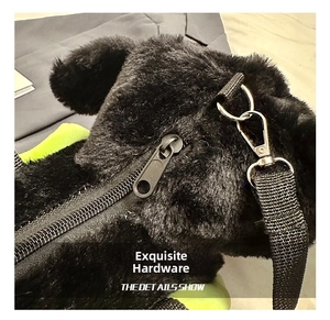 Detailed close-up of the silver metal zipper and soft black plush fabric on the bag