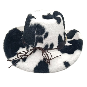 Detail of plush cow print cowboy hat featuring a brown faux leather band and bow