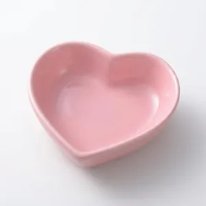Minimalist pink heart-shaped ceramic dipping dish with smooth glazed finish on white background