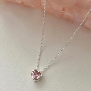 Macro shot of 925 sterling silver necklace with delicate pink heart-shaped zircon stone