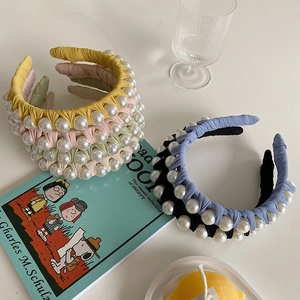 Detailed view of woven fabric headband with large white pearls in assorted pastel colors
