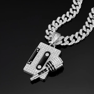 Macro shot of silver hip-hop necklace with iced-out cassette and microphone pendant