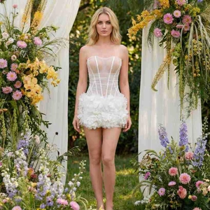 Close-up of white mesh corset top and petal-layered skirt on a romantic floral background