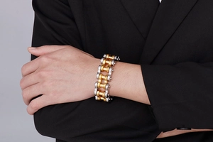 Detail of 22mm gold and silver stainless steel bicycle chain bracelet on a male model