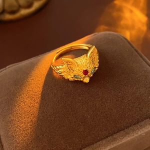 Macro shot of gold fox ring with green gemstone eyes on a velvet jewelry box